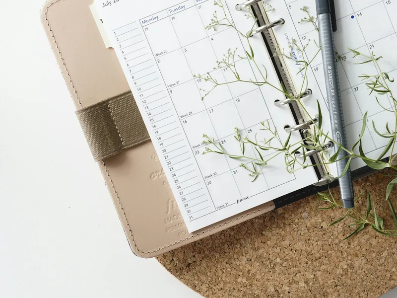 The Studio Operating Kit: a ruled planner sheet on a small stack, a pen beside it